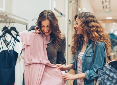 two young women choosing dresses in a luxury fashion store